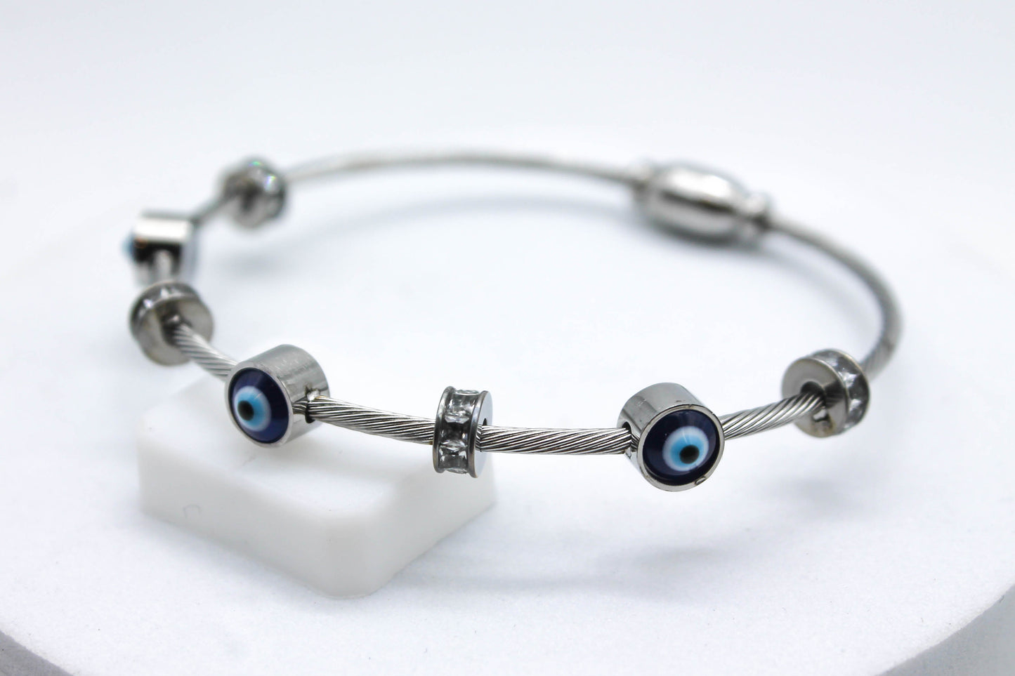 BRAZALETE TRES OJOS TURCOS Y CIRCONIAS; TONO PLATEADO
