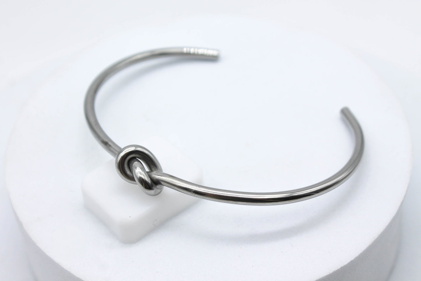 BRAZALETE RIGIDO NUDO; TONO PLATEADO