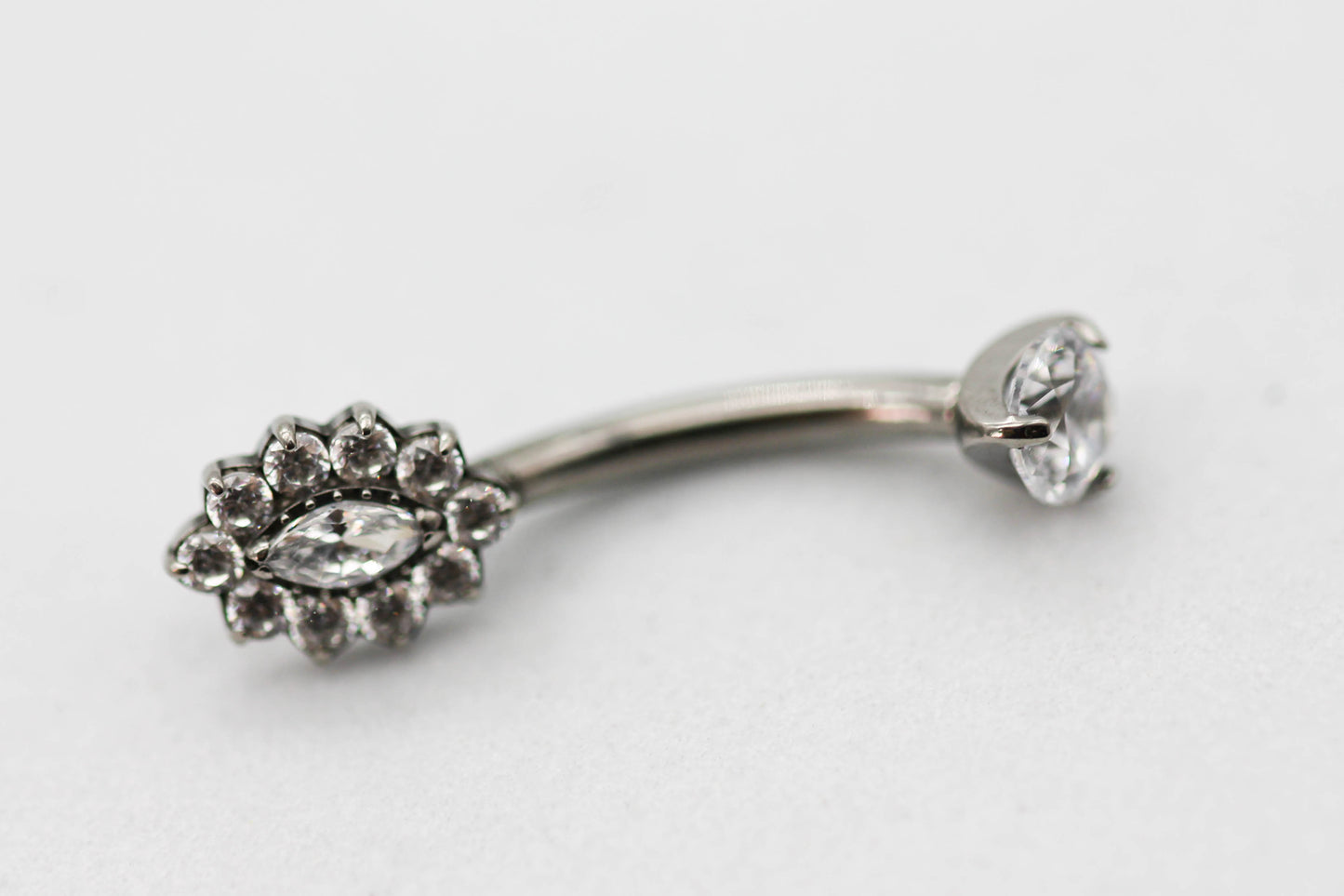 PIERCING OMBLIGO CIRCONIA MONTADA 4MM, FLOR ALARGADA CIRCONIAS; TONO PLATEDO