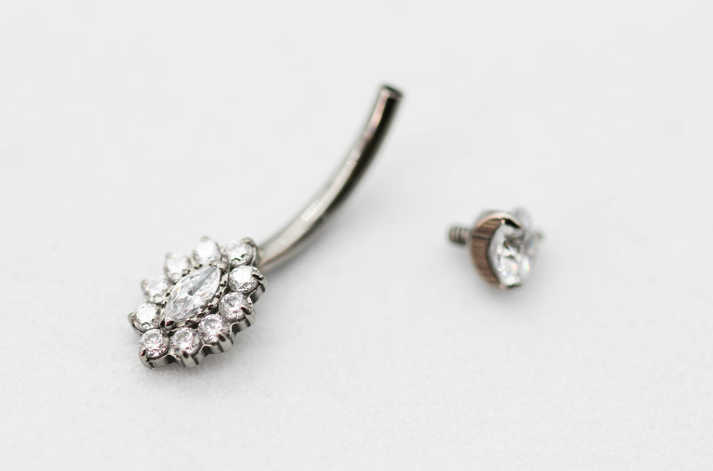 PIERCING OMBLIGO CIRCONIA MONTADA 4MM, FLOR ALARGADA CIRCONIAS; TONO PLATEDO