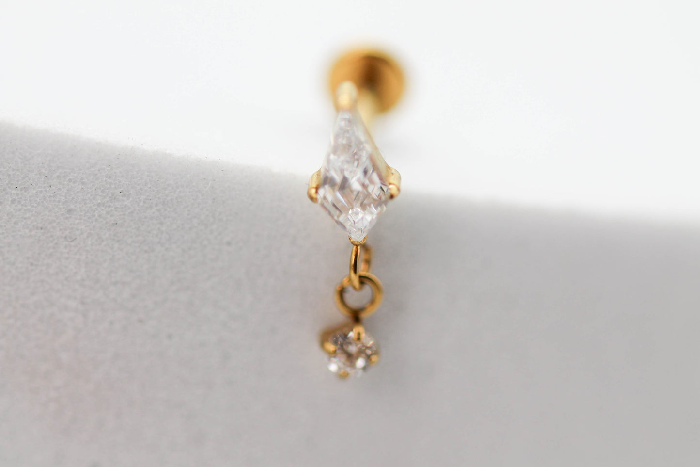 PIERCING ROMBO ALARGADO 7MM, MINI CIRCONIA 2MM COLGANDO; TONO DORADO