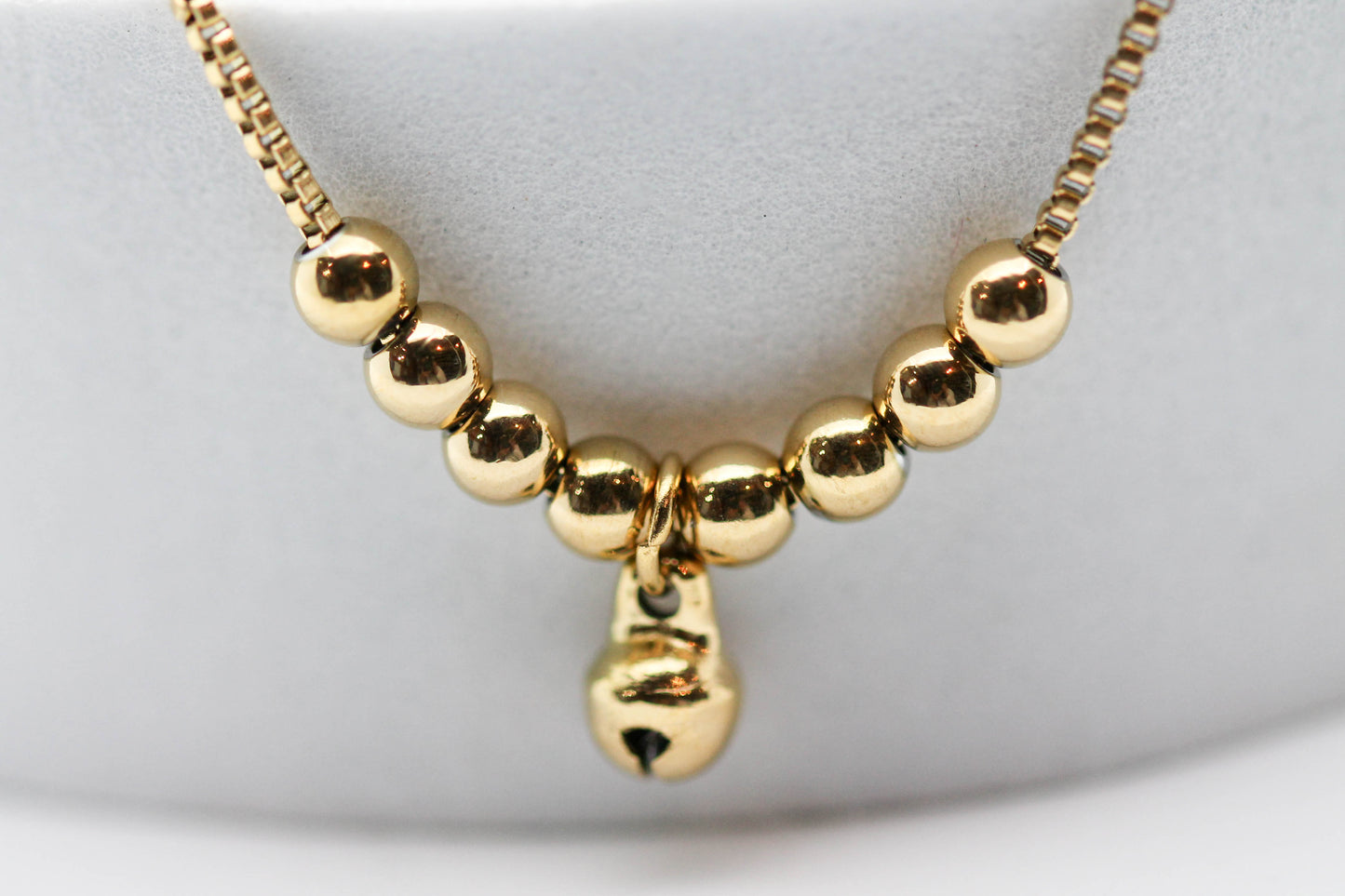 COLLAR CADENA CUADRADA 8 ESFERAS (4MM) CASCABEL AL CENTRO COLGANDO (5MM), 45CM + EXTENSION DE 5CM, TONO DORADO