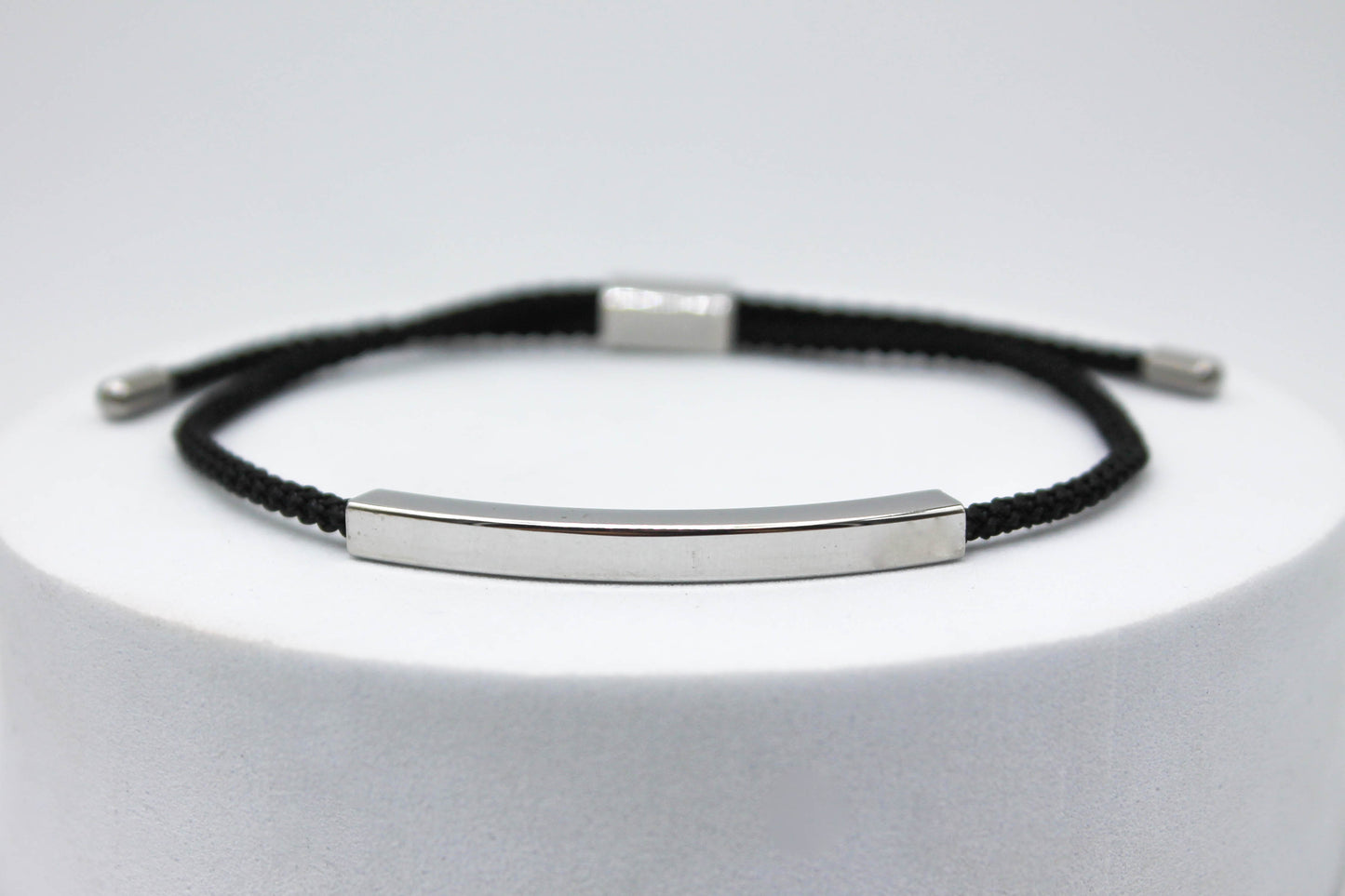 PULSERA UNISEX AJUSTABLE CORDON NEGRO; TONO PLATEADO