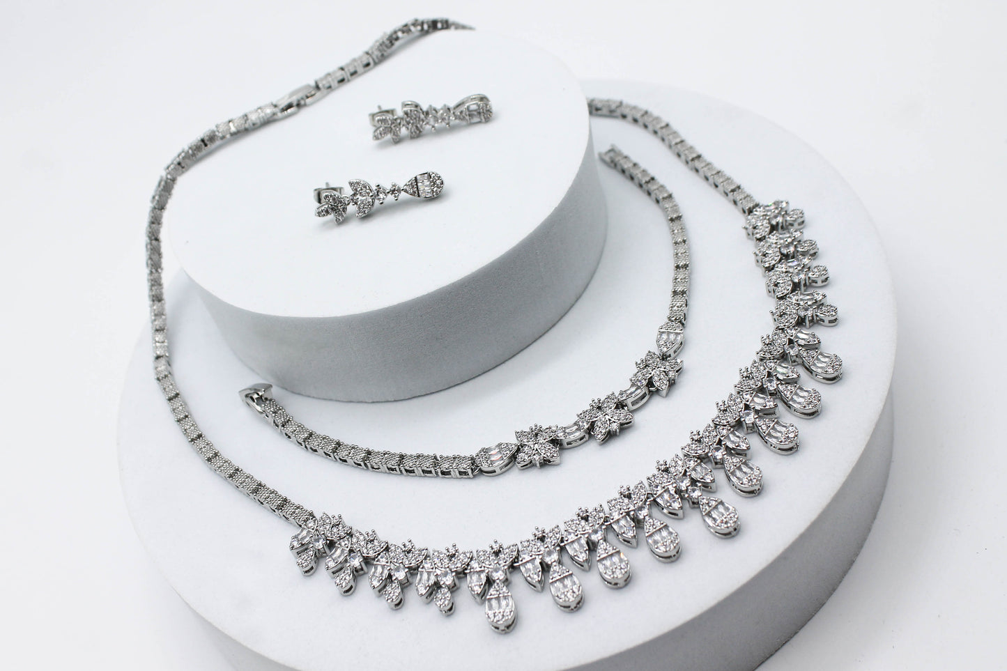 SET HOJA / GOTA CRISTALES BLANCOS; ARETE 2.5CM DR LARGO; PULSERA 19CM; COLLAR 47CM; TONO PLATEADO