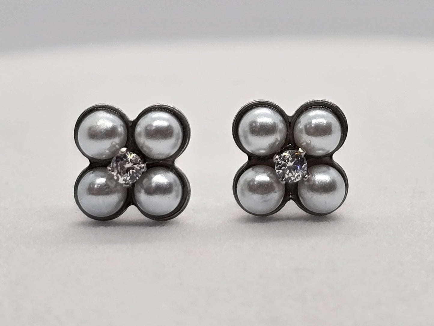 BROQUELES CUATRO PERLAS CIRCONIA AL CENTRO 5X5MM CON TOPE DE ROSCA; TONO PLATEADO
