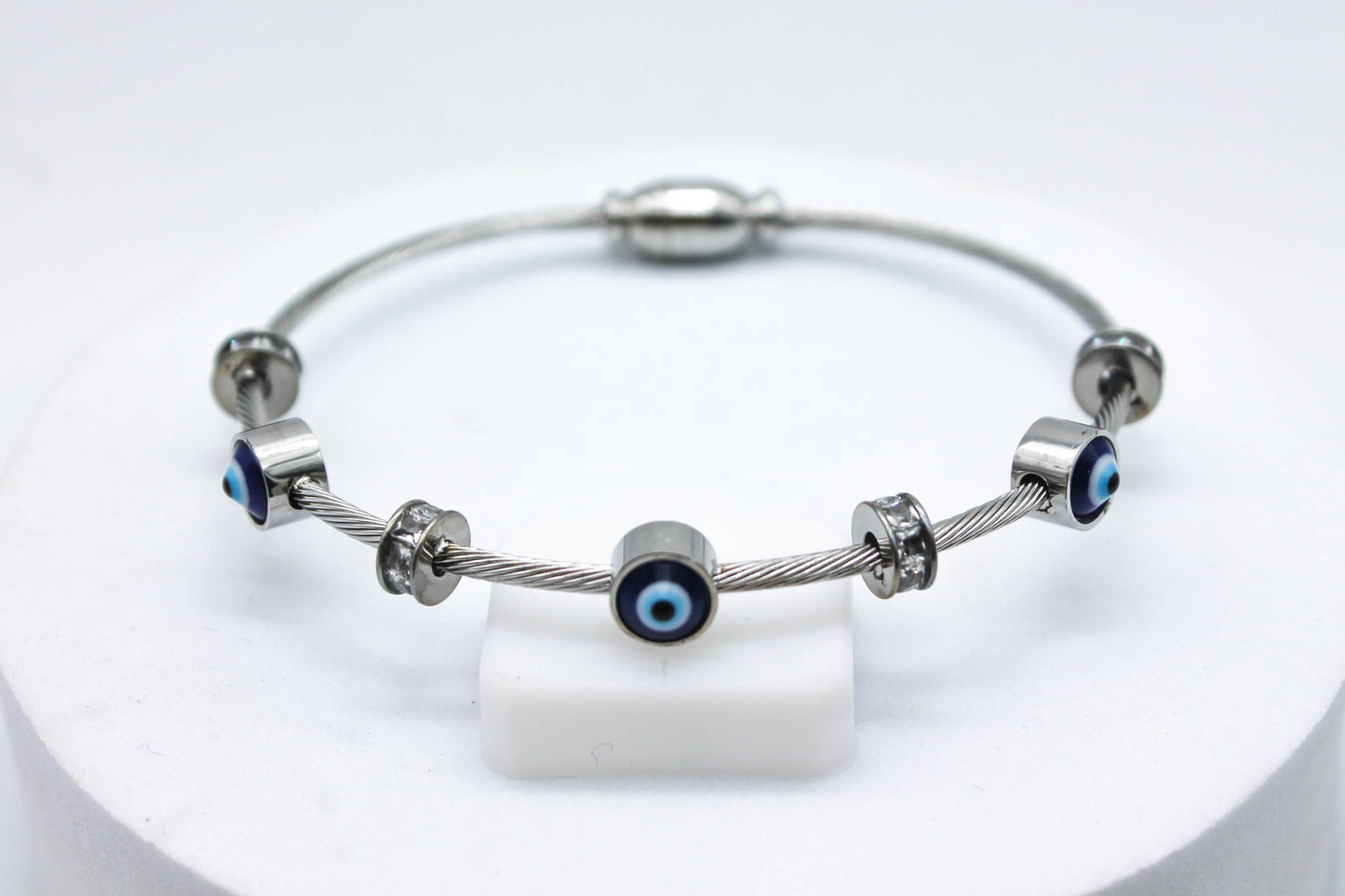 BRAZALETE TRES OJOS TURCOS Y CIRCONIAS; TONO PLATEADO