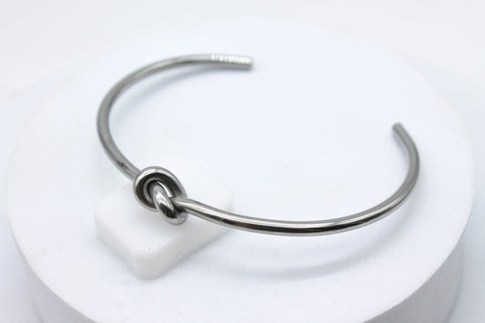 BRAZALETE RIGIDO NUDO; TONO PLATEADO