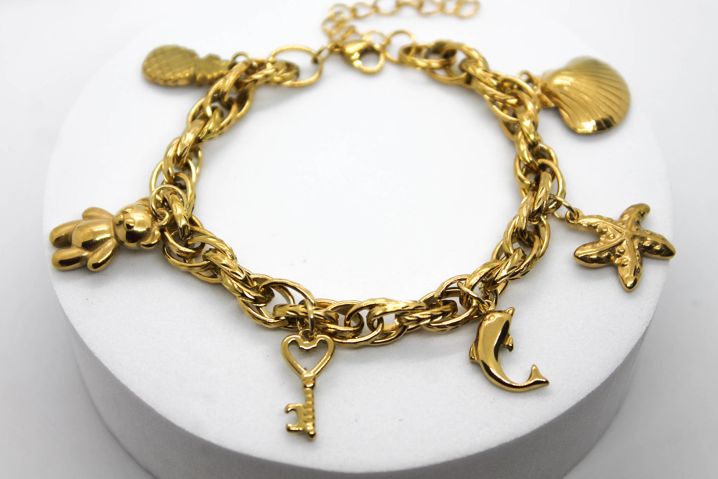 PULSERA DIJES COLGANTES PIÑA, OSO, LLAVE, DELFIN, ESTRELLA DE MAR, CONCHA; TONO DORADO