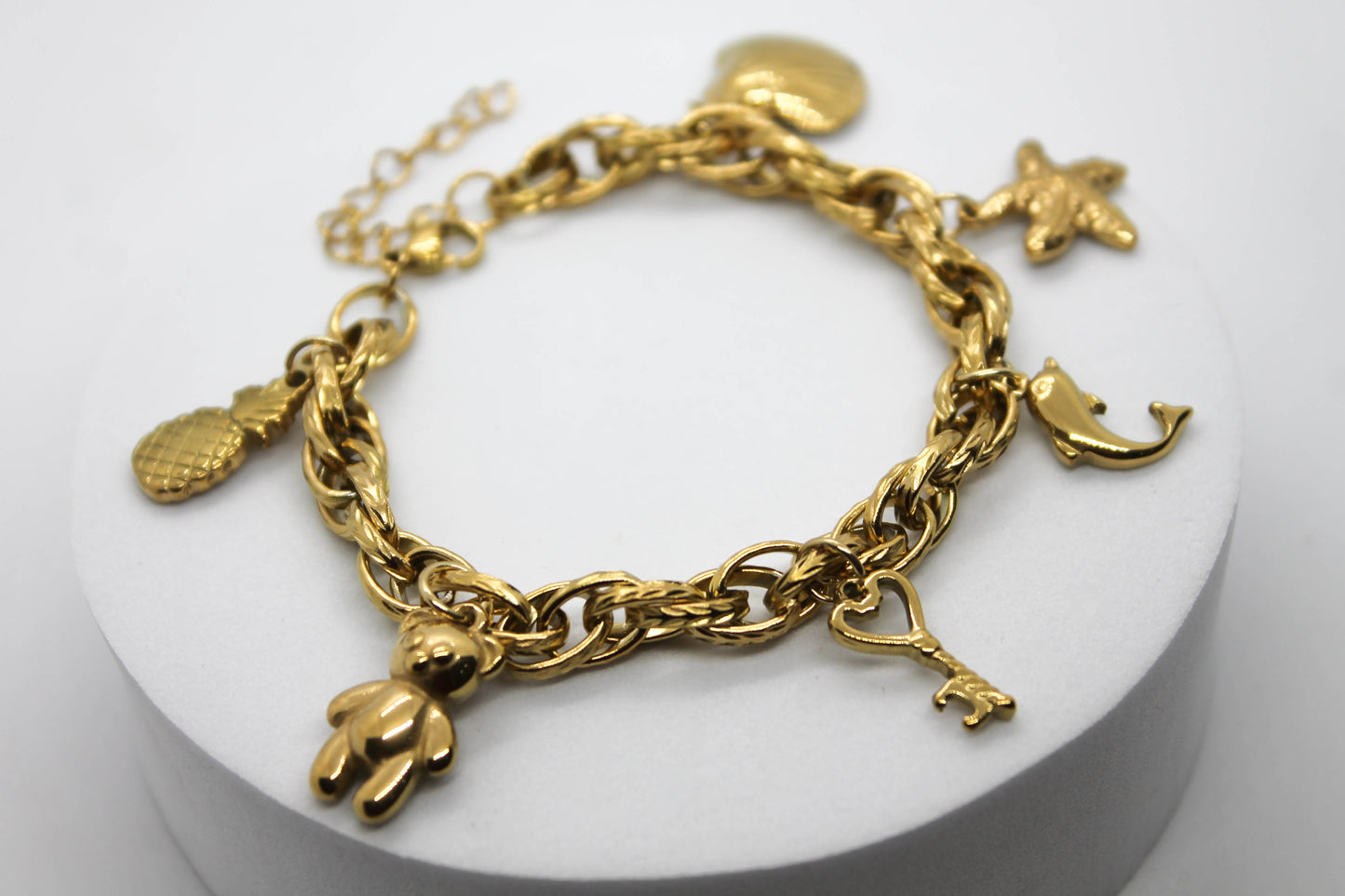 PULSERA DIJES COLGANTES PIÑA, OSO, LLAVE, DELFIN, ESTRELLA DE MAR, CONCHA; TONO DORADO