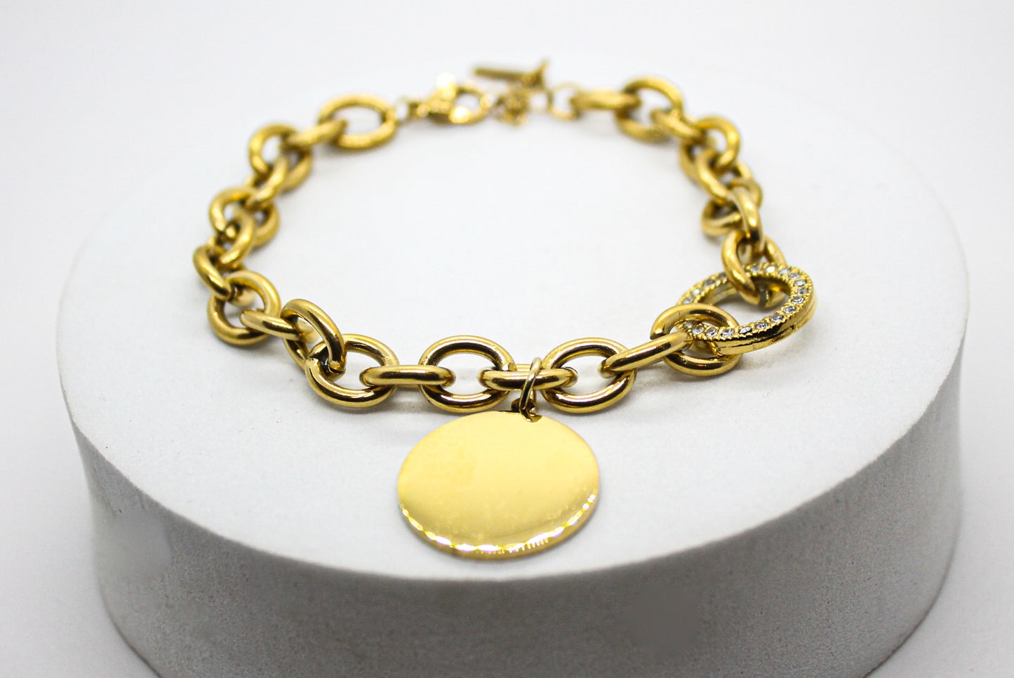 PULSERA ESLABONES GRUESOS, DONA CIRCONIAS, PLACA CIRCULAR; TONO DORADO