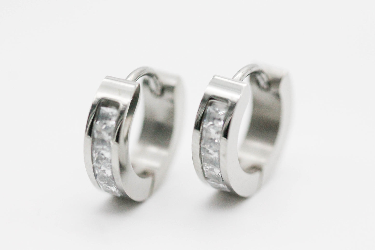 HUGGIES LISOS PLANO ANCHO LINEA DE CIRCONIAS INCRUSTADAS BLANCAS 16X3MM; TONO PLATEADO