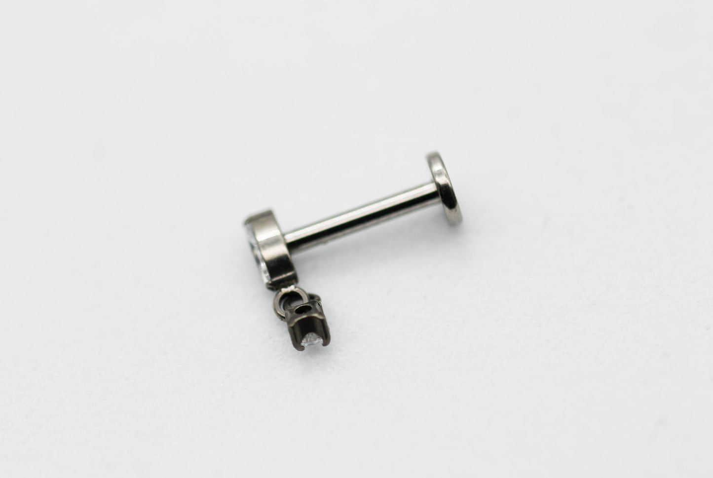 PIERCING ROMBO ALARGADO CIRCONIA 4MM, MINI CIRCONIA 2MM COLGANDO; TONO PLATEADO