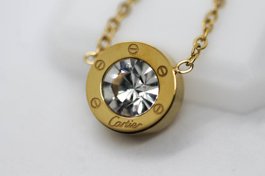 COLLAR DIJE REDONDO CIRCONIA LOGO CARTIER; TONO DORADO