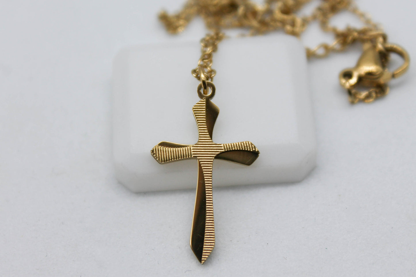 COLLAR CRUZ CON RELIEVE RAYADO; CADENA 45CMS + 5CMS DE EXTENSION; DIJE 22MM; TONO DORADO