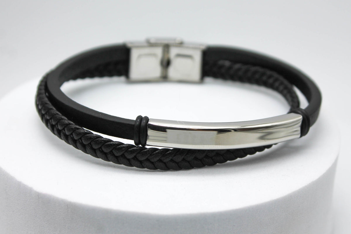 PULSERA CABALLERO PIEL NEGRA DOBLE PLANA Y TRENZADA PLACA ACERO; TONO PLATEADO