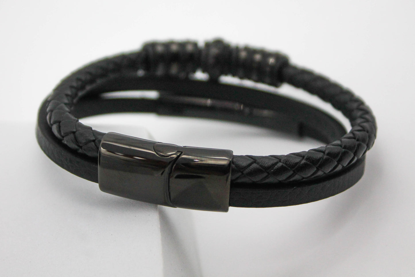 PULSERA CABALLERO PIEL NEGRA TRIPLE DOS LISAS UNA TRENZADA TUBULAR PLACA ACERO; TONO NEGRO