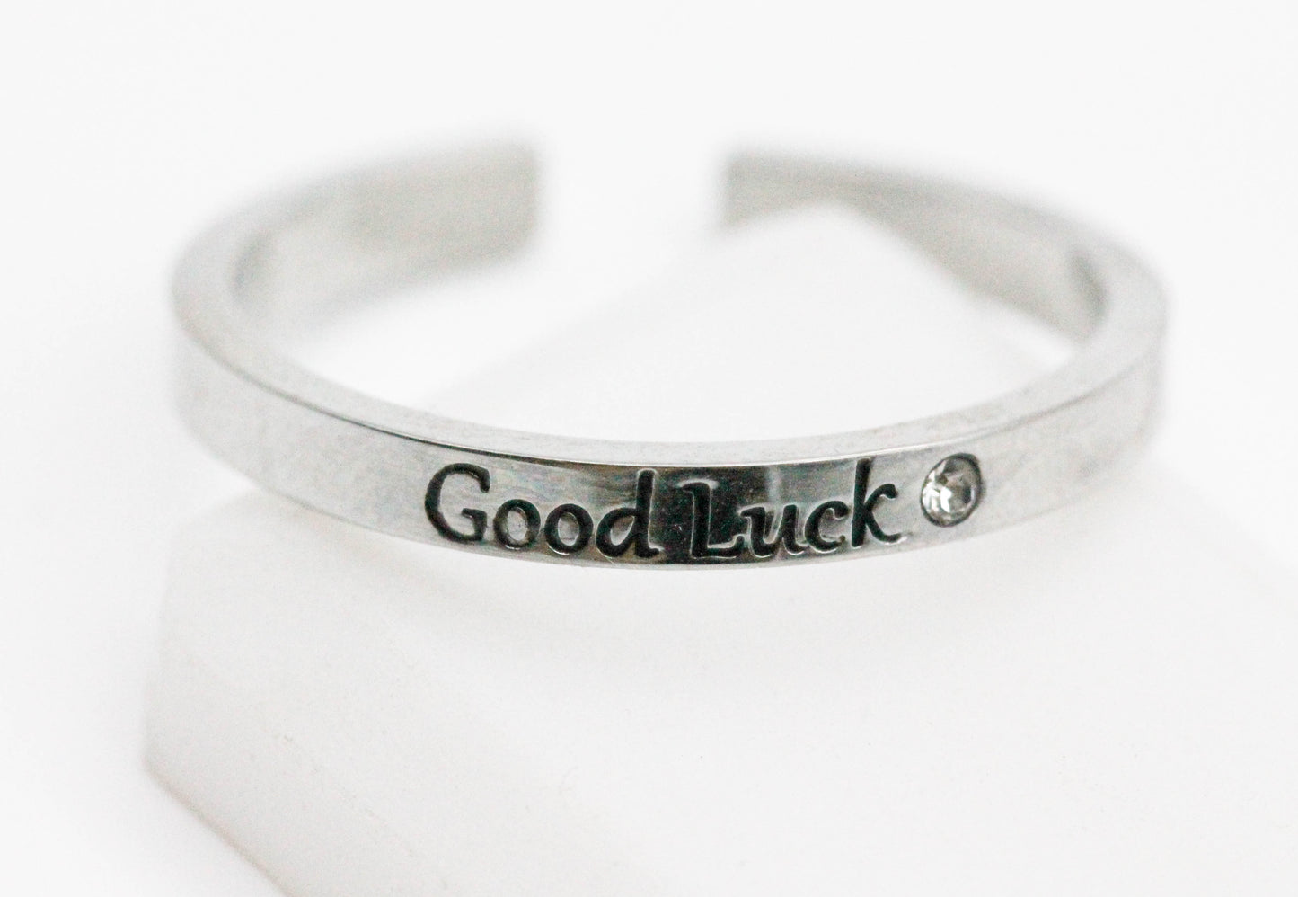 ANILLO AJUSTABLE SOLITARIO "GOOD LUCK", TONO PLATEADO