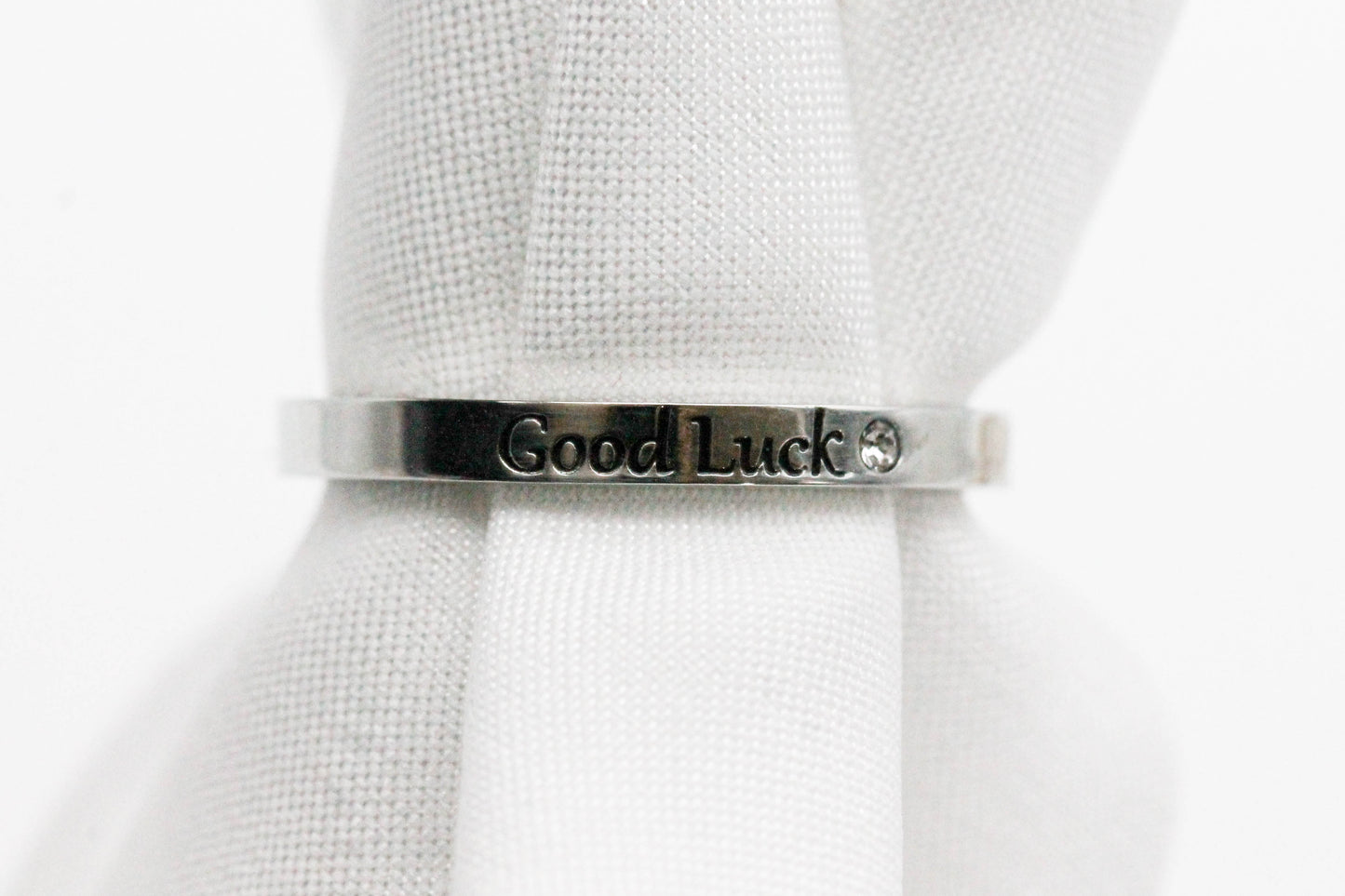 ANILLO AJUSTABLE SOLITARIO "GOOD LUCK", TONO PLATEADO