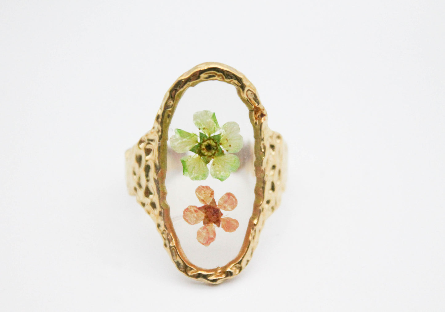 ANILLO AJUSTABLE FLORES VERDE Y SALMON EN BASE OVAL TRANSPARENTE, TONO DORADO