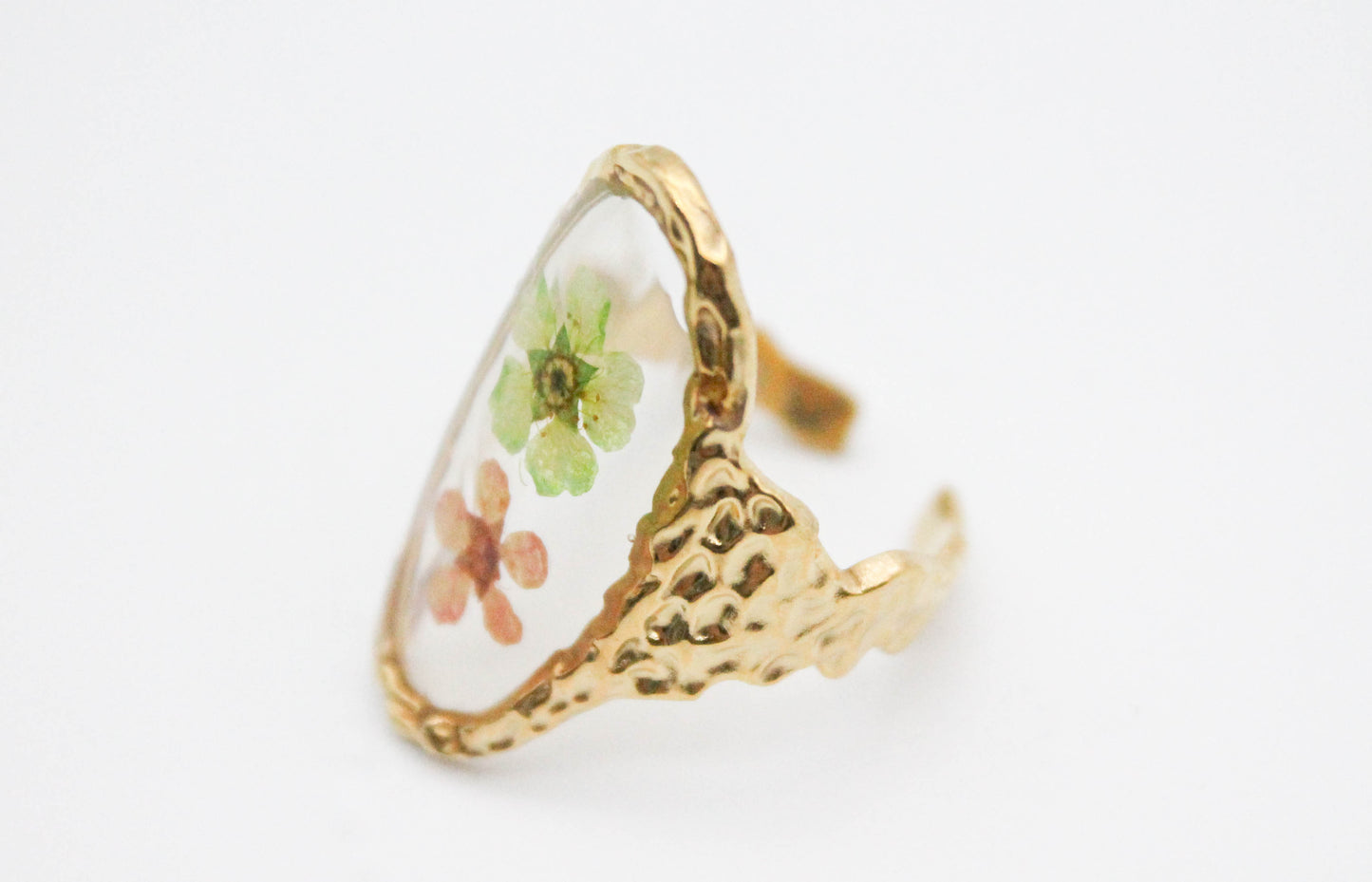 ANILLO AJUSTABLE FLORES VERDE Y SALMON EN BASE OVAL TRANSPARENTE, TONO DORADO