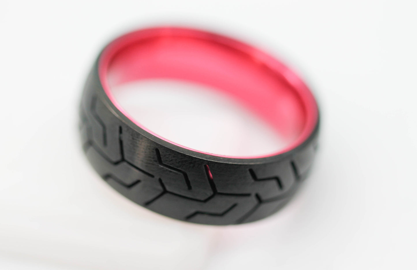 ANILLO CABALLERO NEGRO CON CANALES TIPO RODADURA; INTERIOR, FILOS Y DESTELLOS ROJO METÁLICO