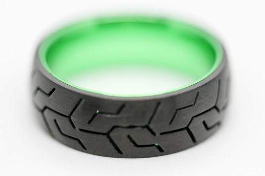 ANILLO CABALLERO NEGRO CON CANALES TIPO RODADURA; INTERIOR, FILOS Y DESTELLOS VERDE METÁLICO