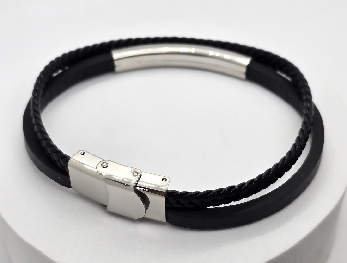 PULSERA CABALLERO PIEL NEGRA DOBLE PLANA Y TRENZADA PLACA ACERO; TONO PLATEADO