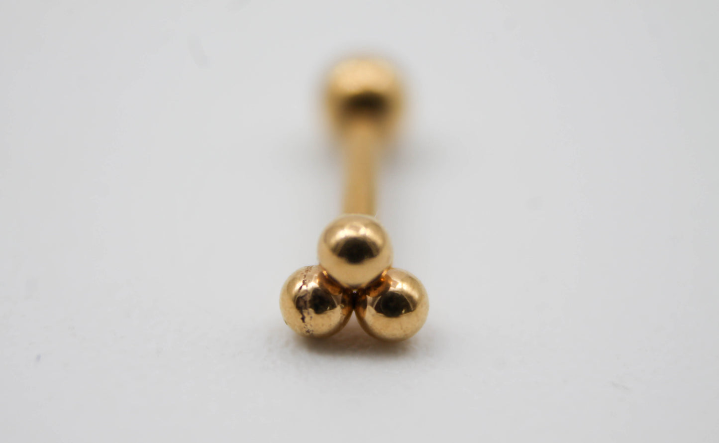 PIERCING FLOR DE 3 ESFERITAS, TONO DORADO