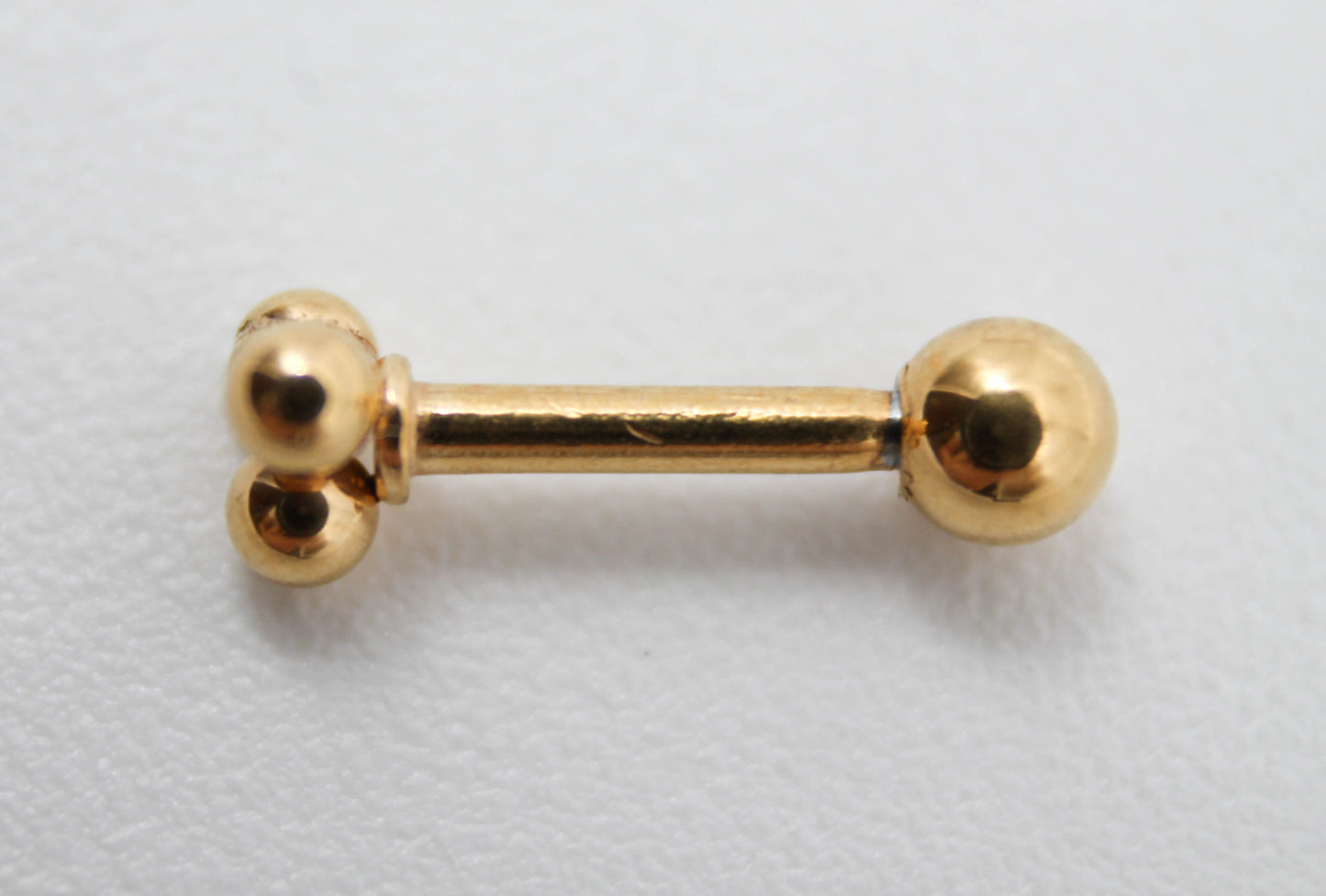 PIERCING FLOR DE 3 ESFERITAS, TONO DORADO