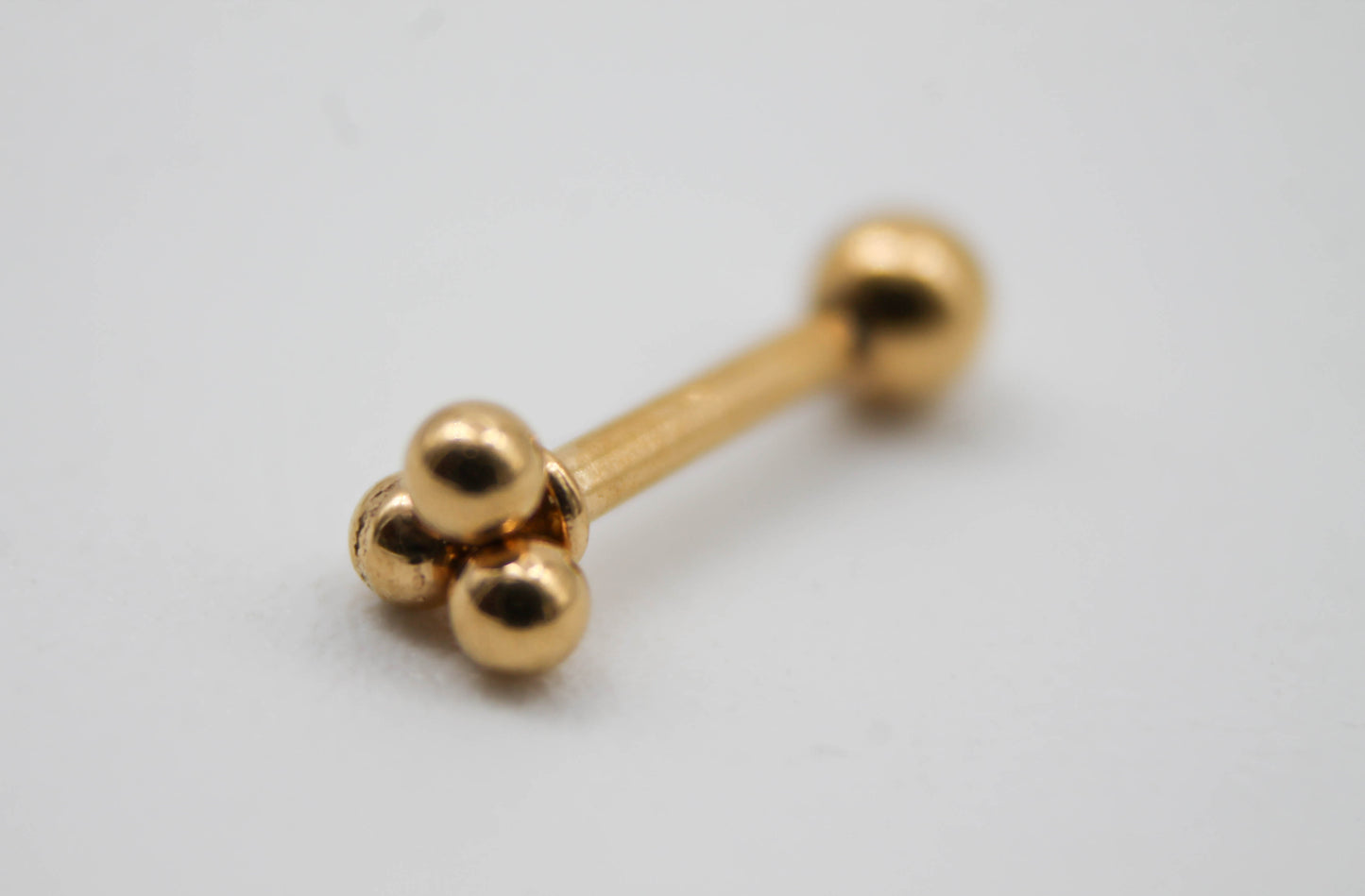 PIERCING FLOR DE 3 ESFERITAS, TONO DORADO